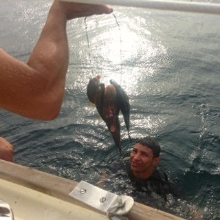 spear fisher handing over his catch