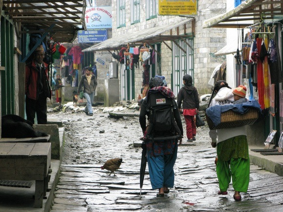 Backpackers walking through Lukla Nepal, talking about what makes you a traveler