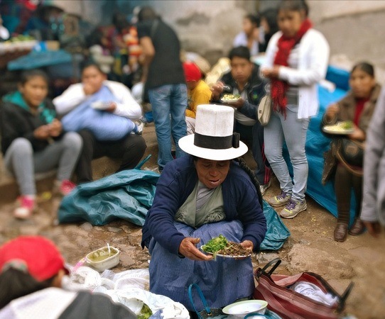 Peruvian woman serving street food in Barratio Market Cusco