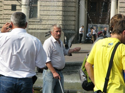 A man in Lviv Ukraine with a pigeon on his arm.