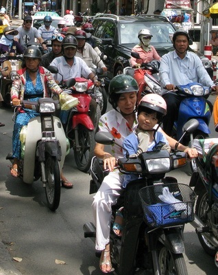 How to cross the road in Saigon? Walk slowly and predictably, and the Busy motorcycle traffic in Vietnam will go around you