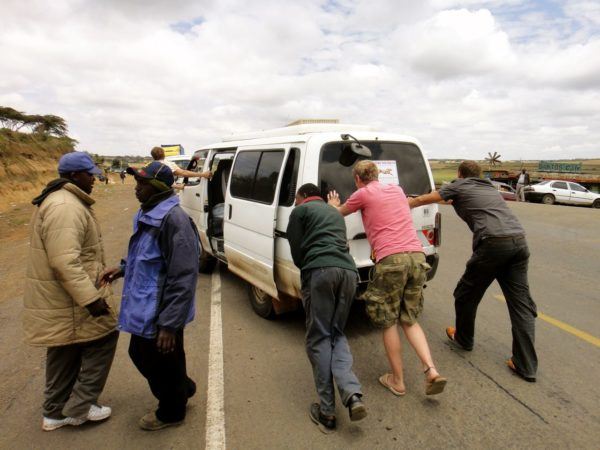 Johnny of OneStep4Ward pushing van to the side of the road with others in Africa