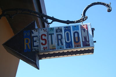 restroom sign made of chopped up license plates; photo by Ryan McCoy