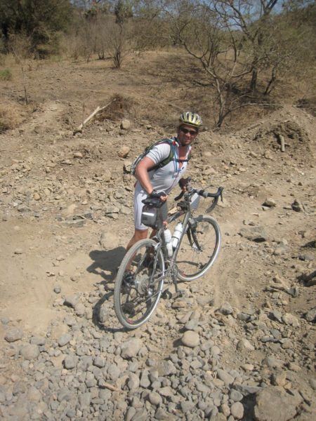 Dave Bouskill navigates rough roads by bicycle on the Tour D'Afrique