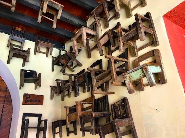 Where to stay in Antigua Guatemala? Try Posada San Sebastian, with dozens of tiny wooden chairs out front.